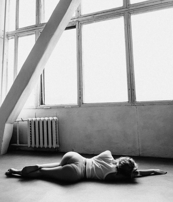 Woman performing a graceful yoga pose in a calm, modern studio.